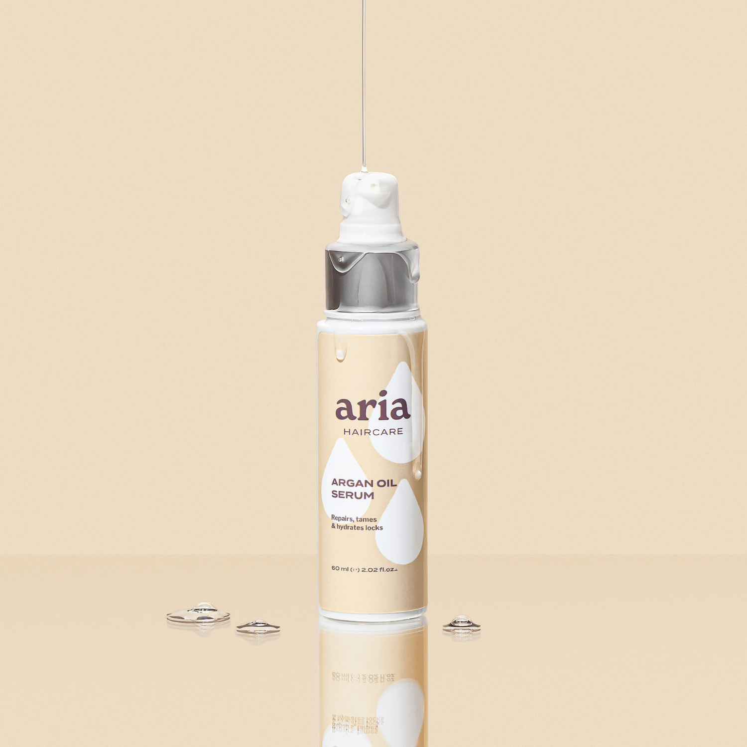 Aria haircare argan oil serum bottle on a beige background