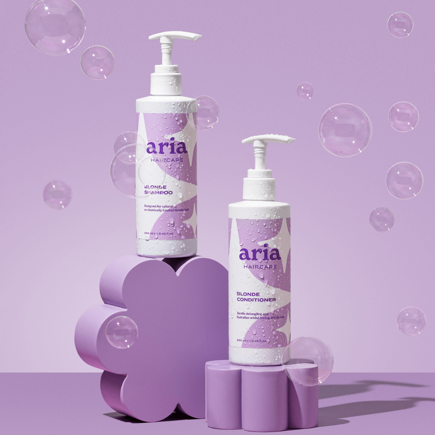 Aria haircare bright and blonde duo on purple background with bubbles