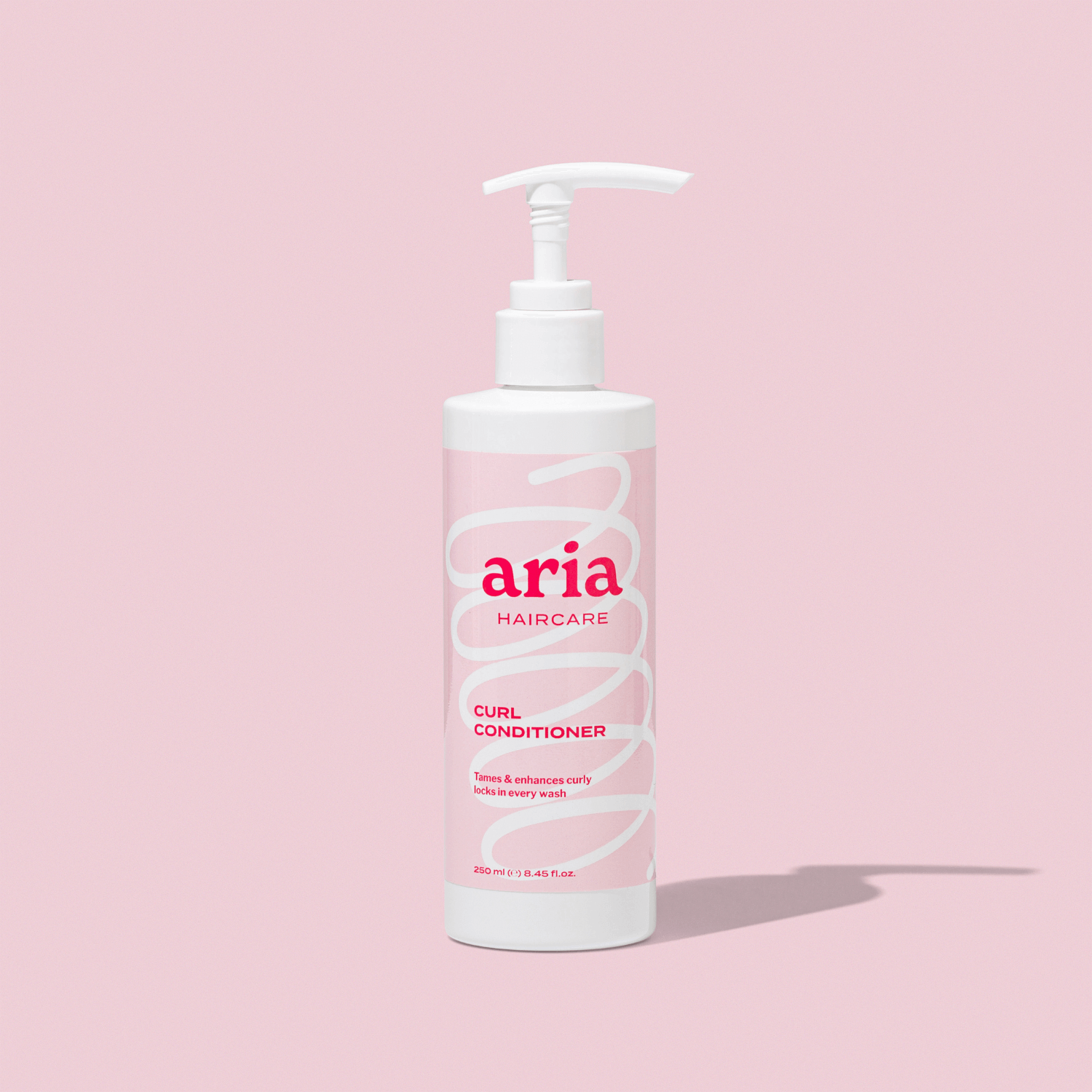 Aria haircare curl conditioner bottle on a pink background