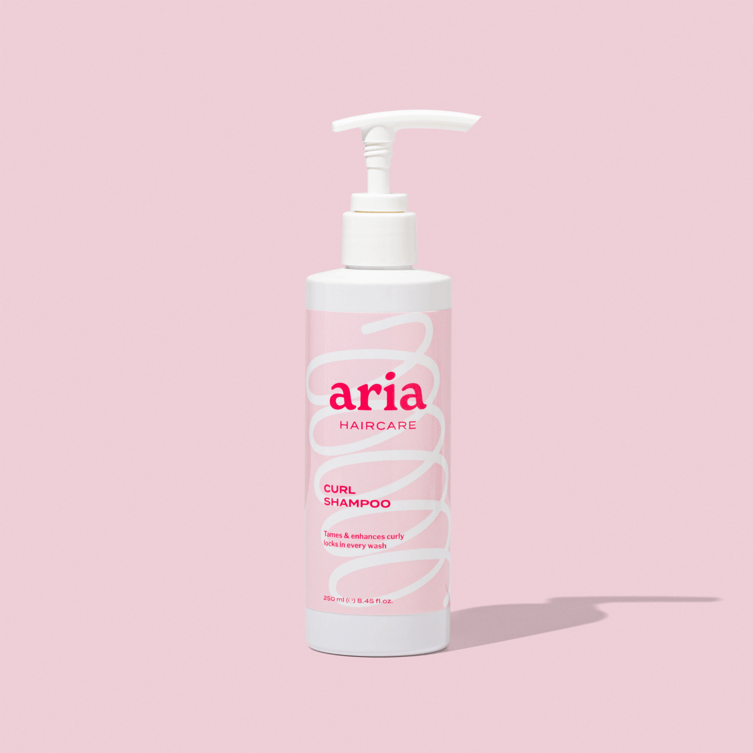 Aria haircare curl shampoo bottle on a pink background