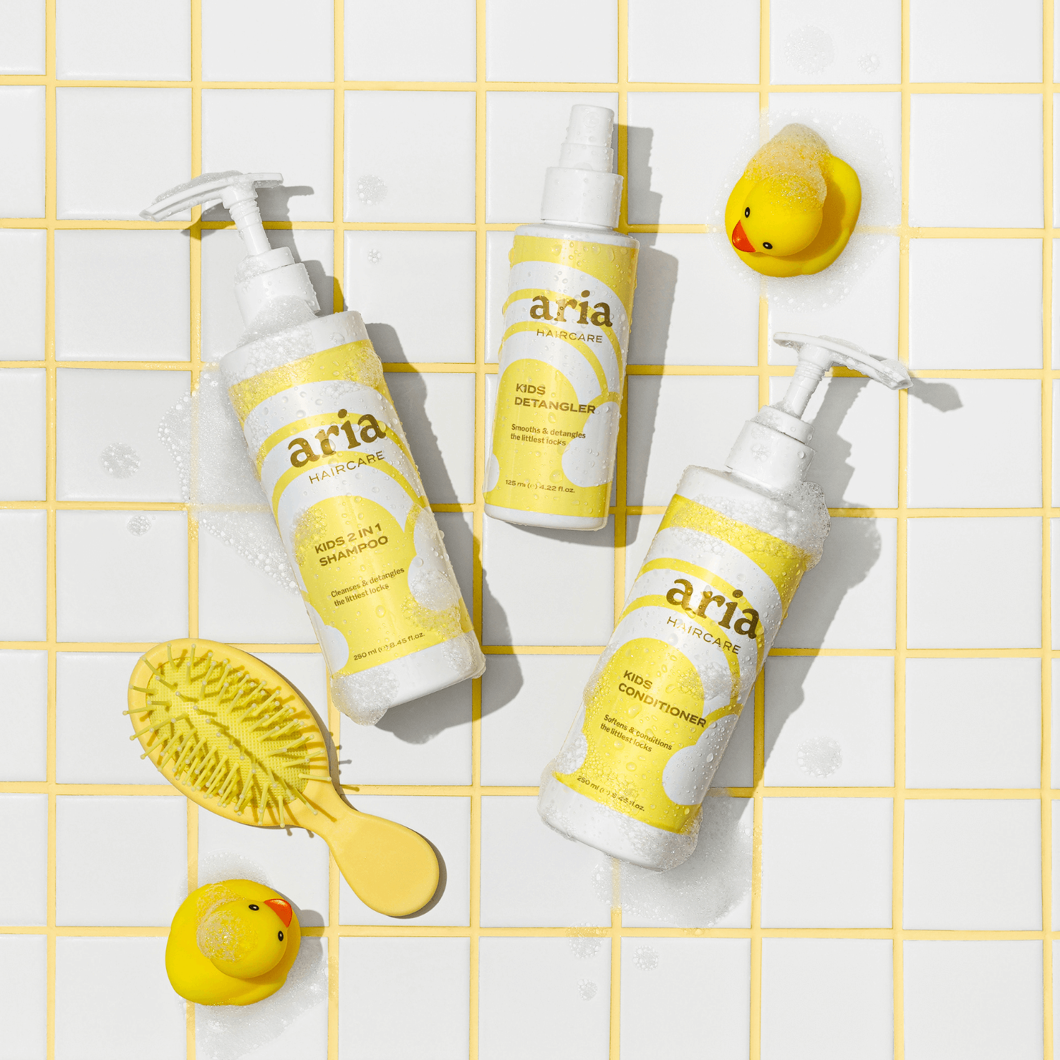 Aria haircare little locks trio kids shampoo, kids conditioner, kids detangler products with a yellow grid background