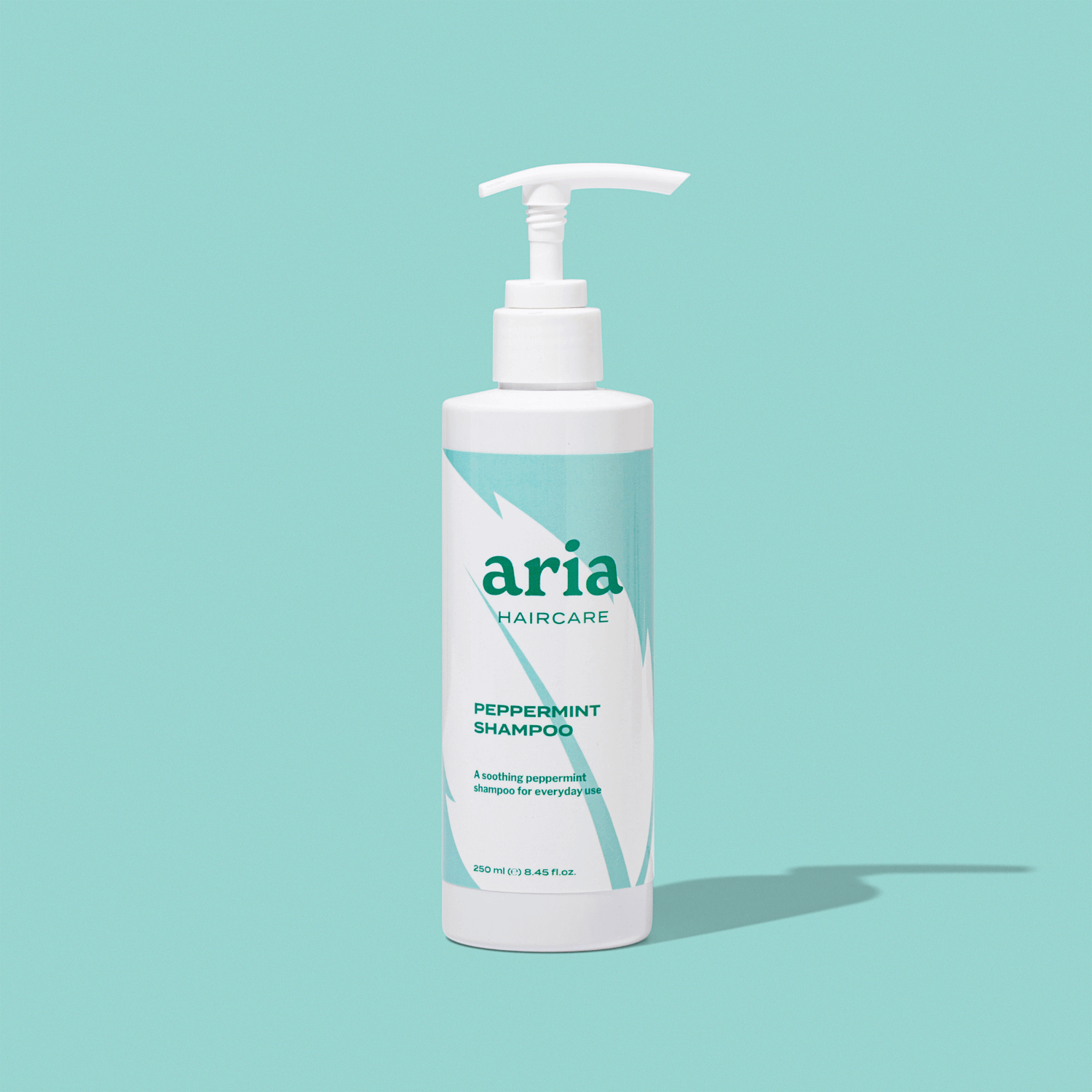 Aria haircare peppermint shampoo bottle on a light blue background