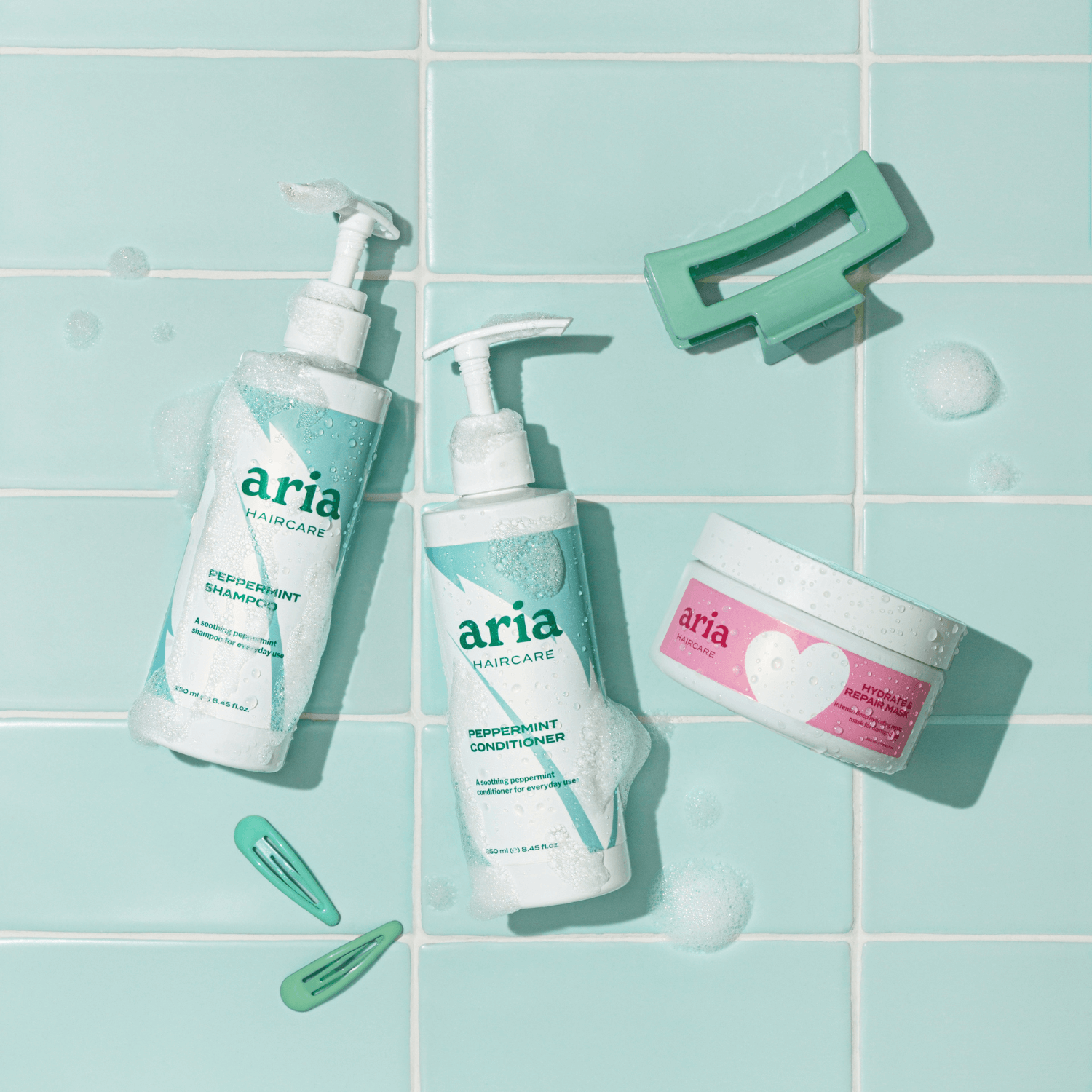 Aria Haircare Scalp Therapy peppermint shampoo, conditioner and hair mask trio on tiled bathroom background